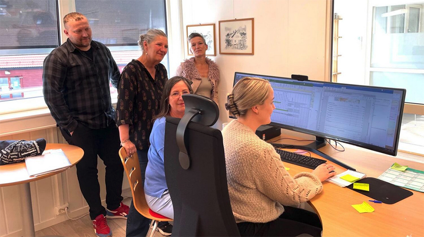 Bilde av fem personer på et kontor.